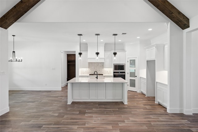 kitchen with oven, a sink, light countertops, backsplash, and stainless steel microwave