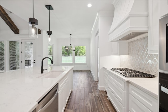 kitchen with tasteful backsplash, dark wood finished floors, custom range hood, appliances with stainless steel finishes, and a sink