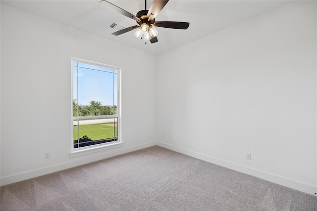 carpeted empty room featuring visible vents, baseboards, and a ceiling fan