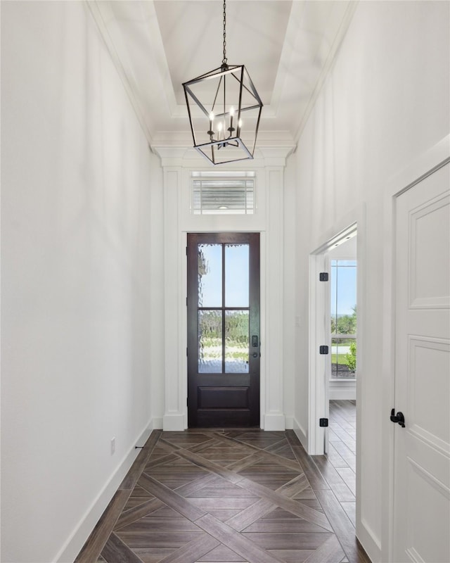 doorway featuring ornamental molding, a wealth of natural light, and baseboards