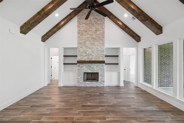 unfurnished living room featuring dark wood-style floors, high vaulted ceiling, a stone fireplace, and visible vents