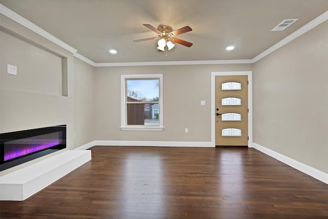 entryway with ornamental molding, dark wood-type flooring, a glass covered fireplace, and visible vents