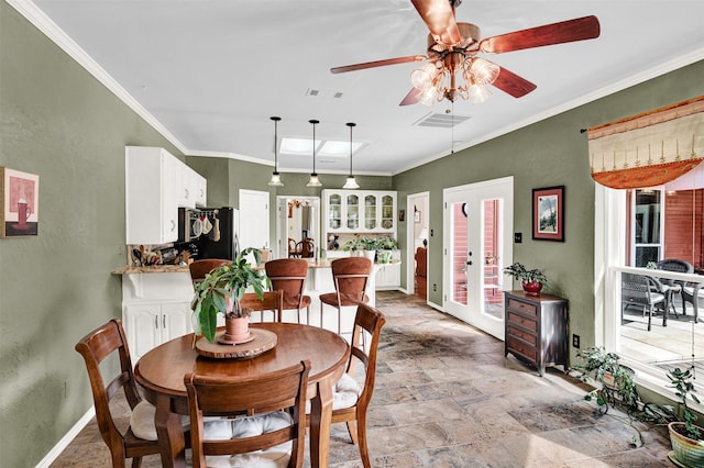 dining area with baseboards, visible vents, ceiling fan, stone finish floor, and ornamental molding