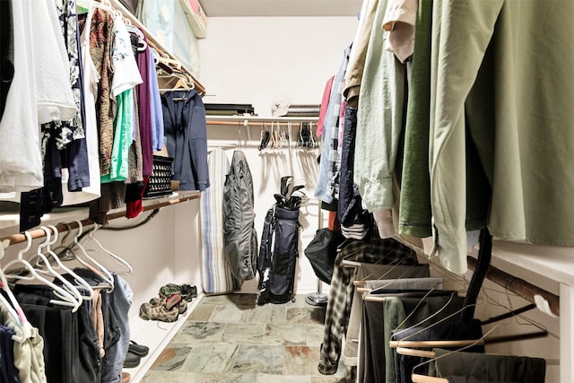 walk in closet with stone finish flooring