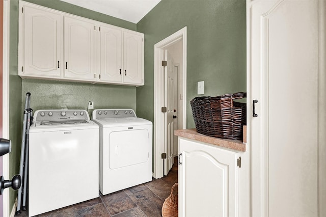 clothes washing area with separate washer and dryer, stone finish floor, and cabinet space