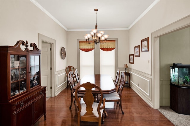 dining area featuring crown molding, a decorative wall, dark wood finished floors, and a notable chandelier