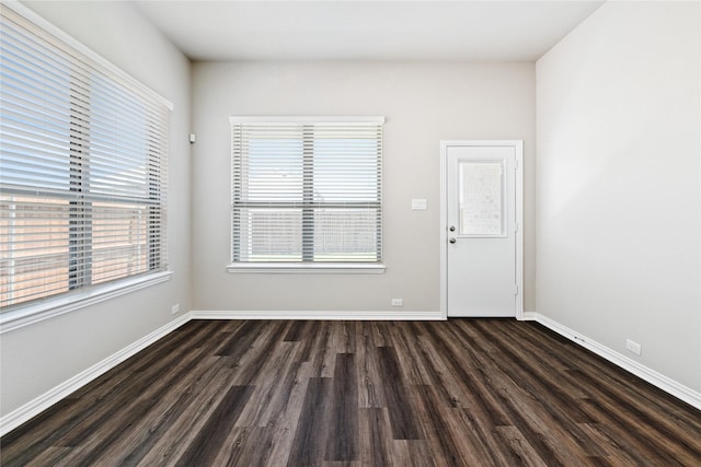 empty room featuring dark wood-type flooring and baseboards