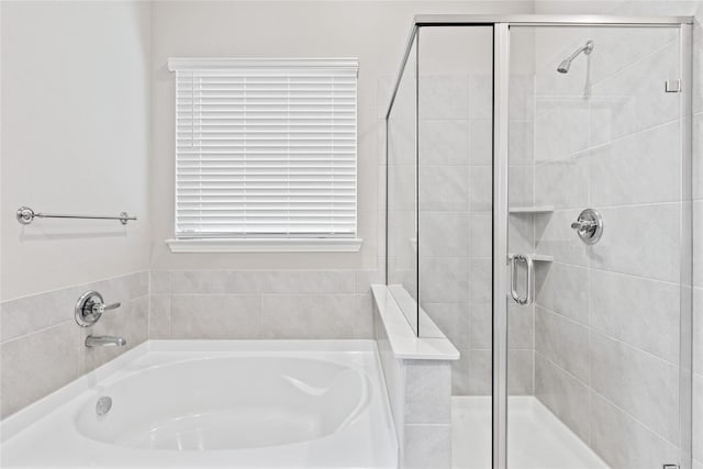 full bathroom featuring a stall shower and a garden tub