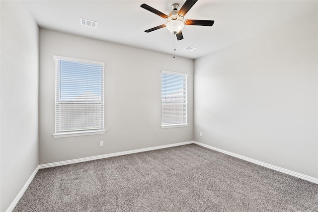 carpeted empty room with a ceiling fan, visible vents, and baseboards