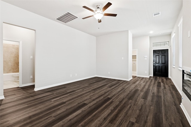 unfurnished living room featuring dark wood-style floors, a ceiling fan, visible vents, and baseboards