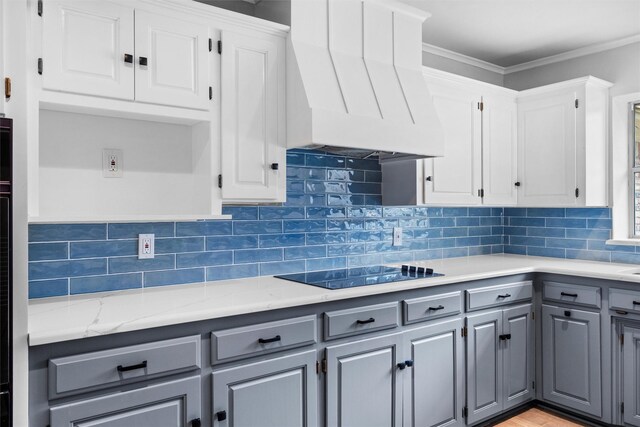 kitchen featuring black electric stovetop, light countertops, gray cabinets, custom exhaust hood, and white cabinetry