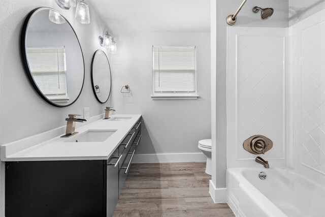 full bathroom featuring a sink, toilet, wood finished floors, and shower / bathtub combination