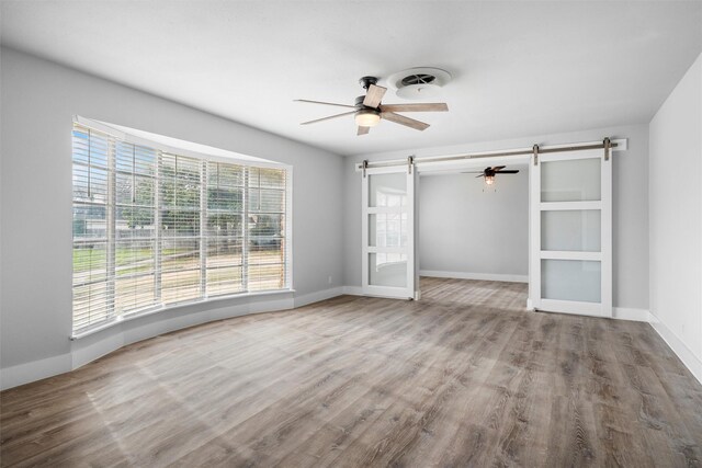 interior space with ceiling fan, baseboards, wood finished floors, and crown molding