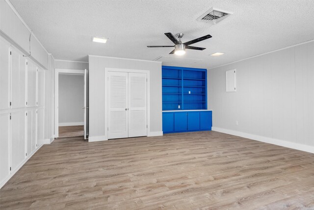 unfurnished bedroom with visible vents, a textured ceiling, light wood-style flooring, and ornamental molding