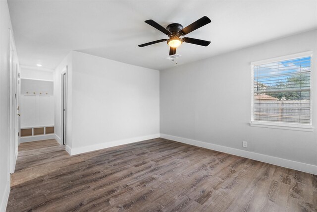 unfurnished room with ceiling fan, baseboards, and wood finished floors