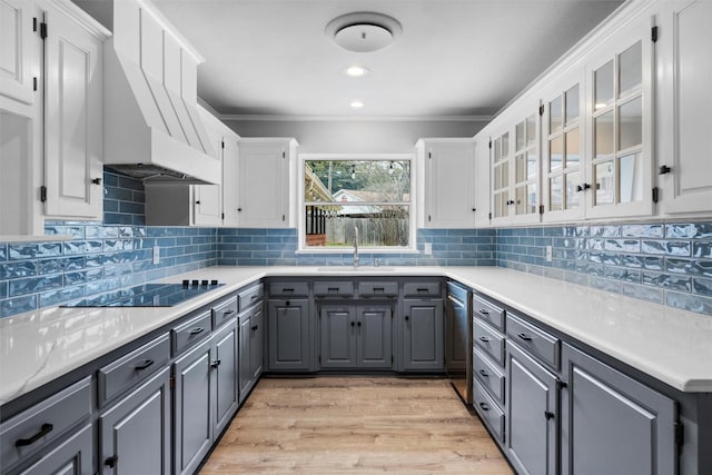 kitchen with a sink, black electric stovetop, white cabinets, and gray cabinetry