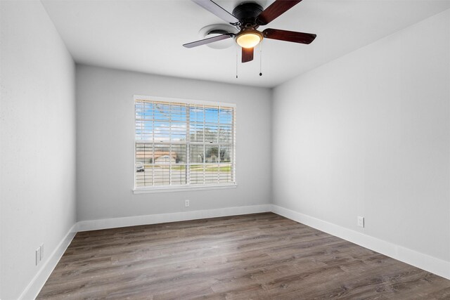 unfurnished room featuring wood finished floors, baseboards, and ceiling fan