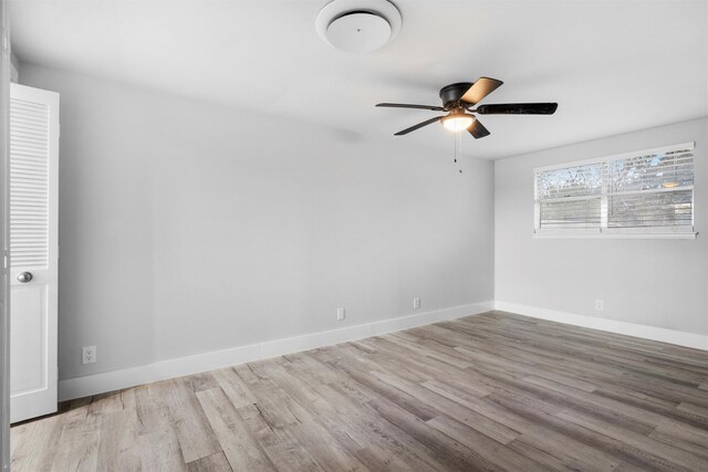 empty room featuring baseboards, wood finished floors, and a ceiling fan