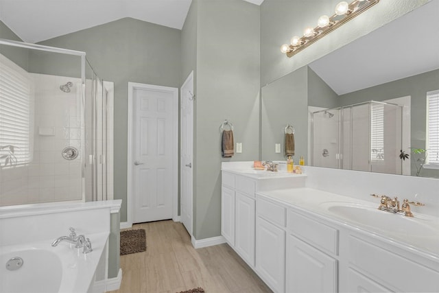 full bathroom featuring a stall shower, a sink, lofted ceiling, and double vanity