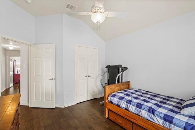 bedroom featuring lofted ceiling, wood finished floors, visible vents, baseboards, and a closet