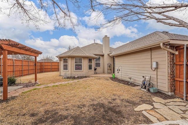 back of property featuring a lawn, a chimney, fence, a patio area, and a pergola