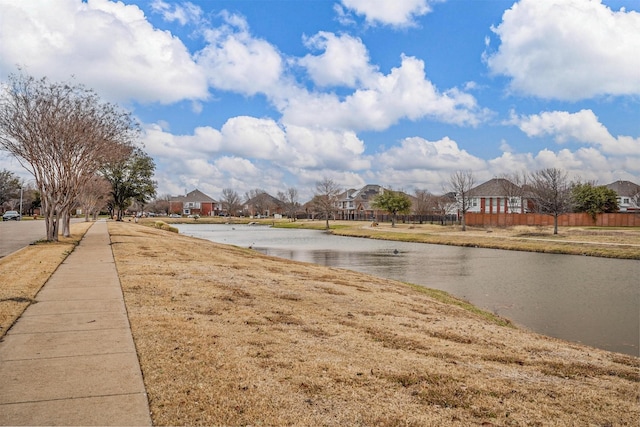 view of road with a water view, sidewalks, and a residential view