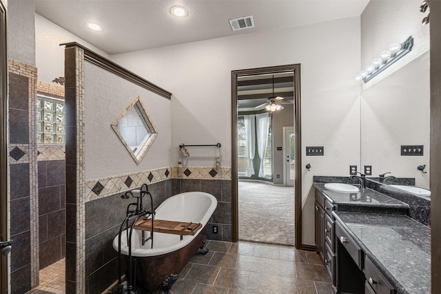 bathroom featuring visible vents, a soaking tub, vanity, tile walls, and recessed lighting