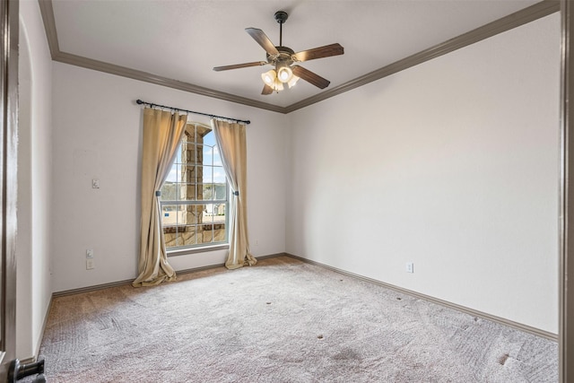 spare room with carpet floors, crown molding, baseboards, and ceiling fan