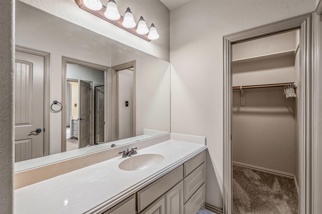 bathroom with a spacious closet and vanity