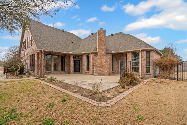 rear view of house featuring brick siding, fence, roof with shingles, a chimney, and a patio area