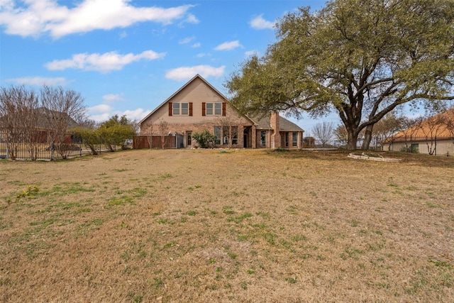 exterior space featuring brick siding, fence, and a lawn