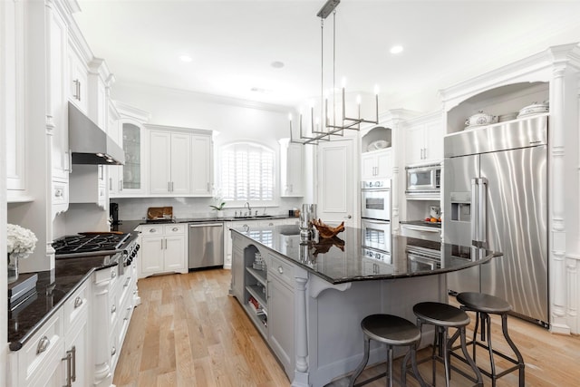 kitchen with stainless steel appliances, a sink, ventilation hood, a center island, and open shelves