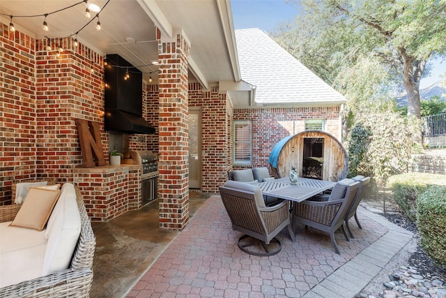 view of patio featuring exterior kitchen and a grill