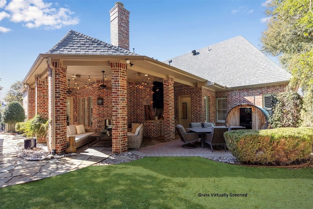 rear view of property with a patio, brick siding, a chimney, and an outdoor living space