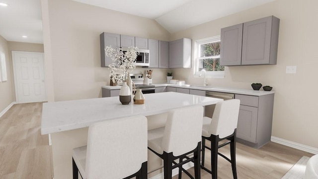 kitchen featuring gray cabinets, stainless steel microwave, a sink, and electric range oven