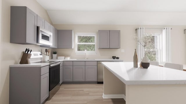 kitchen with white microwave, electric stove, and gray cabinetry