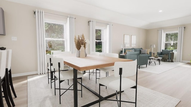 dining space featuring light wood finished floors, plenty of natural light, and baseboards