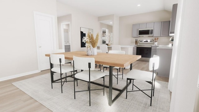 dining room featuring vaulted ceiling, recessed lighting, baseboards, and light wood-style floors