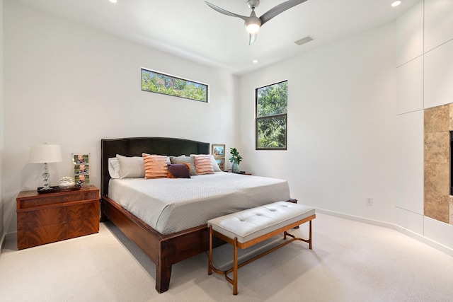 bedroom with light colored carpet, recessed lighting, a ceiling fan, a fireplace, and baseboards