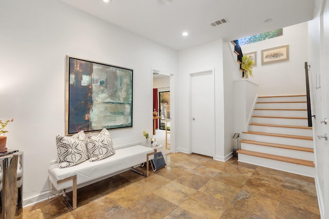 living area featuring stone finish flooring, stairs, recessed lighting, and baseboards