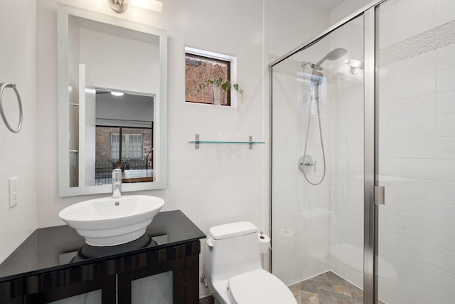 full bathroom featuring a stall shower, toilet, and vanity