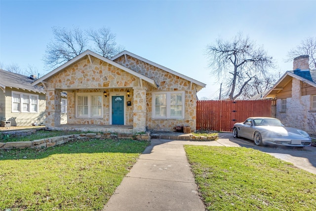 view of front of house featuring a porch, fence, and a front lawn