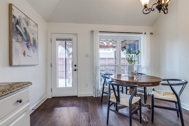 dining space with lofted ceiling, dark wood-style floors, baseboards, and a notable chandelier