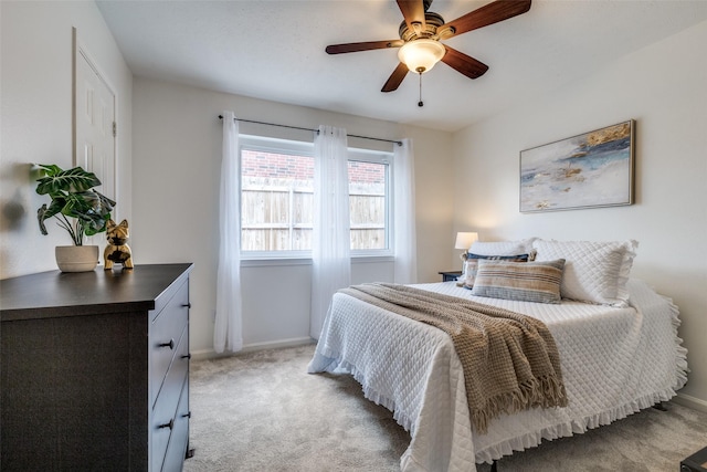 bedroom featuring a ceiling fan, light colored carpet, and baseboards