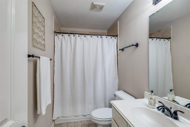 full bathroom featuring visible vents, vanity, toilet, and a textured ceiling