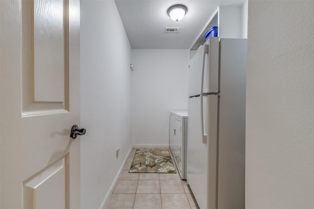 washroom featuring visible vents, light tile patterned flooring, separate washer and dryer, laundry area, and baseboards