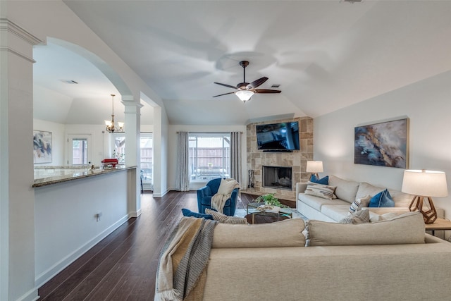 living room featuring visible vents, dark wood finished floors, arched walkways, lofted ceiling, and a fireplace