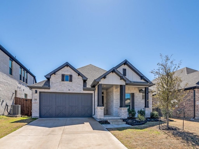 view of front of house featuring a shingled roof, central AC unit, concrete driveway, fence, and brick siding