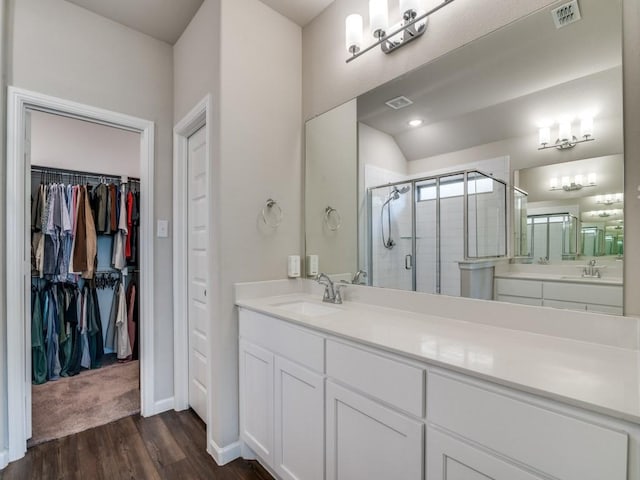 full bath featuring visible vents, a shower stall, vanity, and wood finished floors