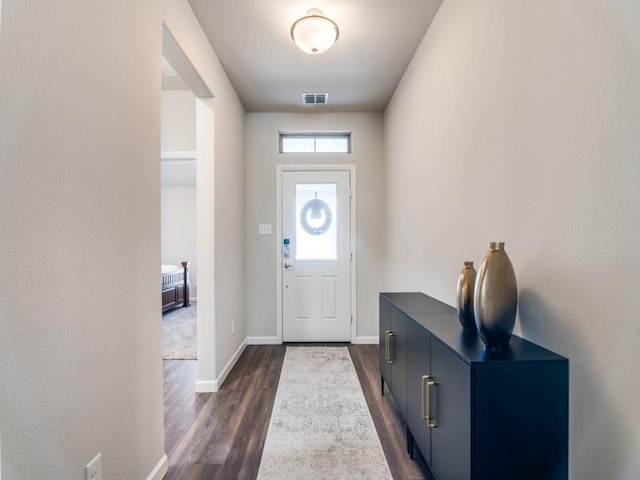 entryway featuring dark wood-type flooring, visible vents, and baseboards